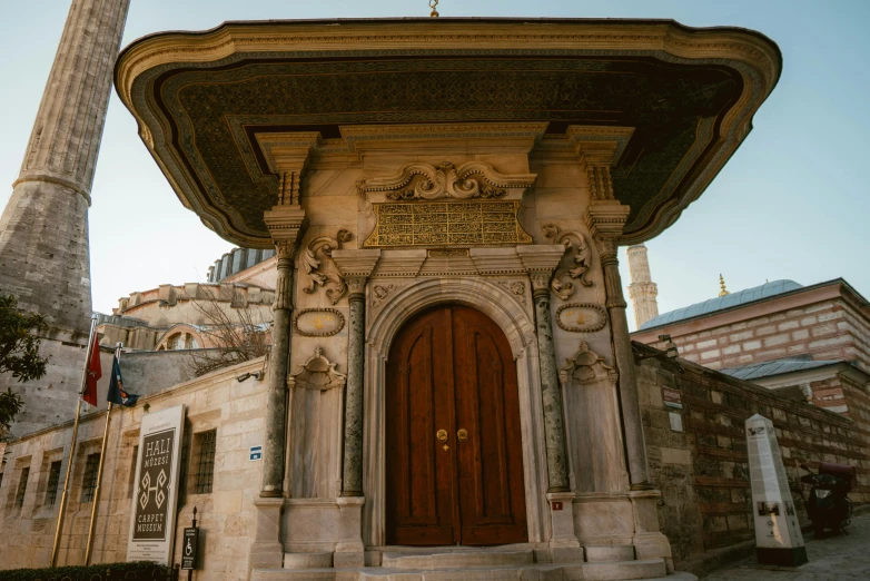 a tall tower with a clock on top of it, a marble sculpture, inspired by Osman Hamdi Bey, pexels contest winner, art nouveau, symmetrical doorway, turkey, wooden toilets, 1505