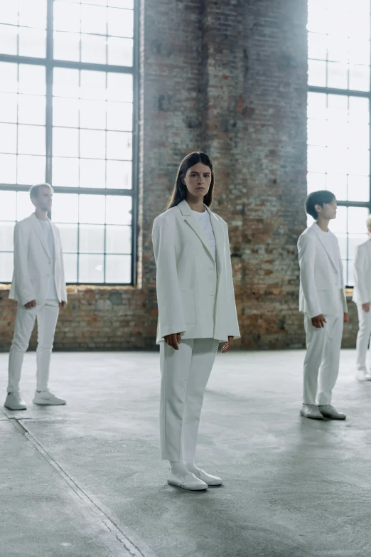 a group of people in white suits standing in a room, inspired by Vanessa Beecroft, unsplash, bauhaus, wearing a track suit, band, looking away, ny