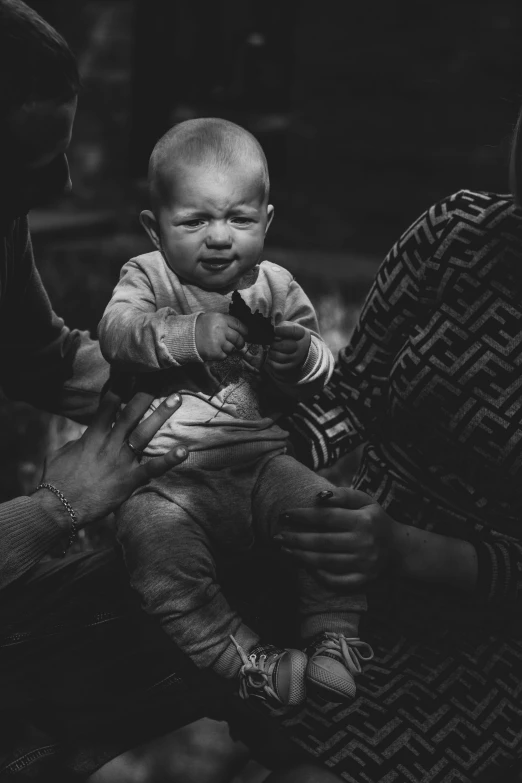 a black and white photo of a woman holding a baby, pexels contest winner, clenching, focus on his foot, with a hurt expression, babies in her lap