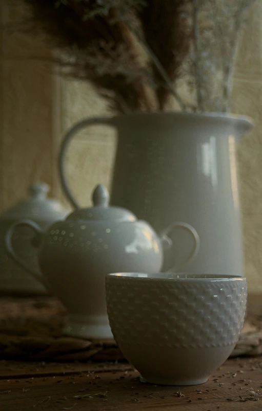 a couple of cups sitting on top of a wooden table, a still life, inspired by Jean Tabaud, flickr, detail shots, white vase, stippled walls, engalnd porcelain tea set