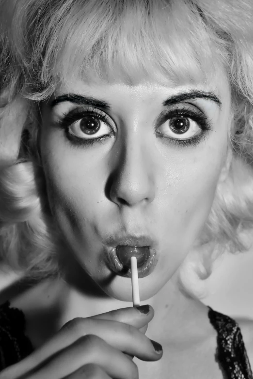 a woman with a cigarette in her mouth, a black and white photo, inspired by Grete Stern, reddit, big eyes, square, lexi belle, about to consume you