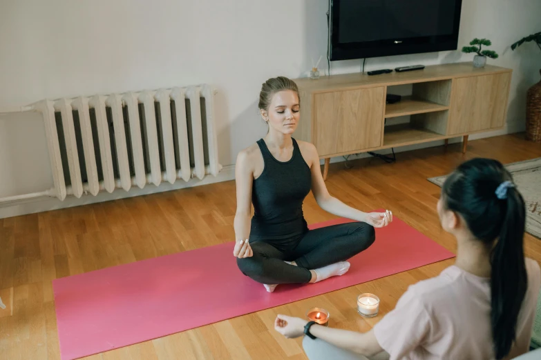 a woman sitting on a yoga mat in a living room, a picture, trending on pexels, hurufiyya, acupuncture treatment, calmly conversing 8k, low quality photo, high quality artwork