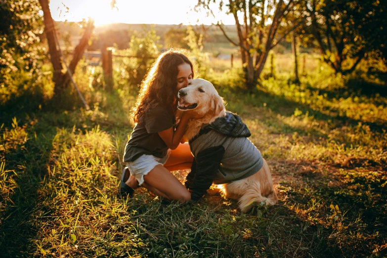 a woman sitting in the grass with a dog, bathed in golden light, hugging each other, profile image, australian