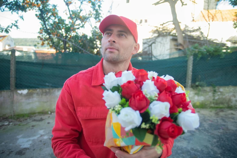 a man in a red shirt holding a bouquet of flowers, wearing a red backwards cap, meni chatzipanagiotou, rex orange county, large)}]
