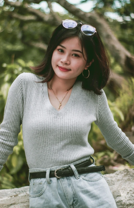 a woman sitting on a rock posing for a picture, wearing casual sweater, malaysian, icon, portrait image