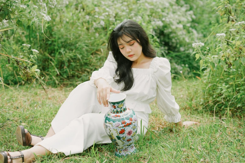 a woman sitting in the grass with a vase, an album cover, inspired by Kim Jeong-hui, unsplash, cloisonnism, white sleeves, bae suzy, catalog photo, 奈良美智