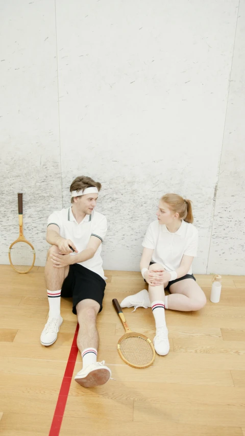 a couple of people sitting on top of a wooden floor, tennis racket, 15081959 21121991 01012000 4k, museum quality photo, sport clothing