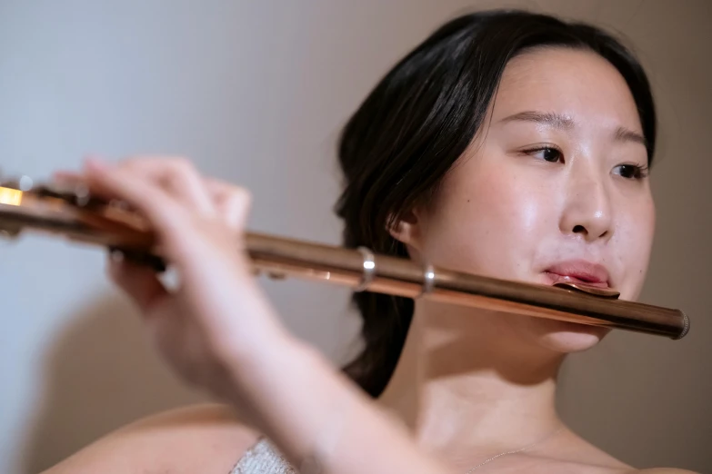 a close up of a person playing a flute, inspired by Zheng Xie, portrait image, heonhwa choe, nicodemus yang-mattisson, brown