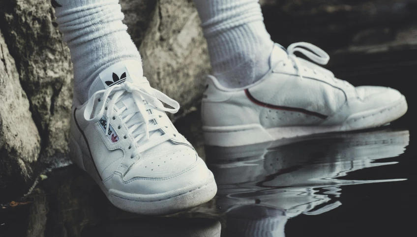 a pair of white sneakers sitting on top of a puddle of water, an album cover, inspired by Elsa Bleda, trending on unsplash, hyperrealism, addidas, creepers, trident, dark taint :: athletic