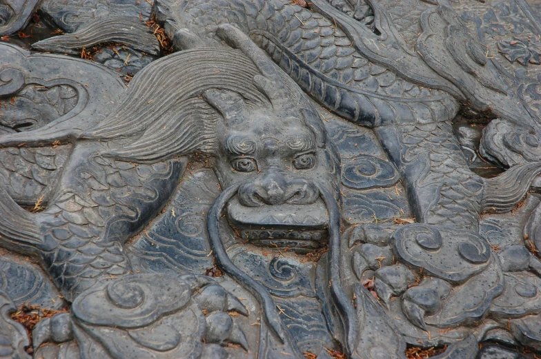 a close up of a carving on a wall, an album cover, inspired by Li Kan, pexels contest winner, sōsaku hanga, black dragon, intricate ground stone, guan yu, carved floor