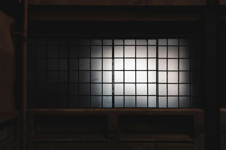 a dimly lit window in a dark room, inspired by Sesshū Tōyō, unsplash, light and space, metal bars, square lines, full daylight, in a warehouse