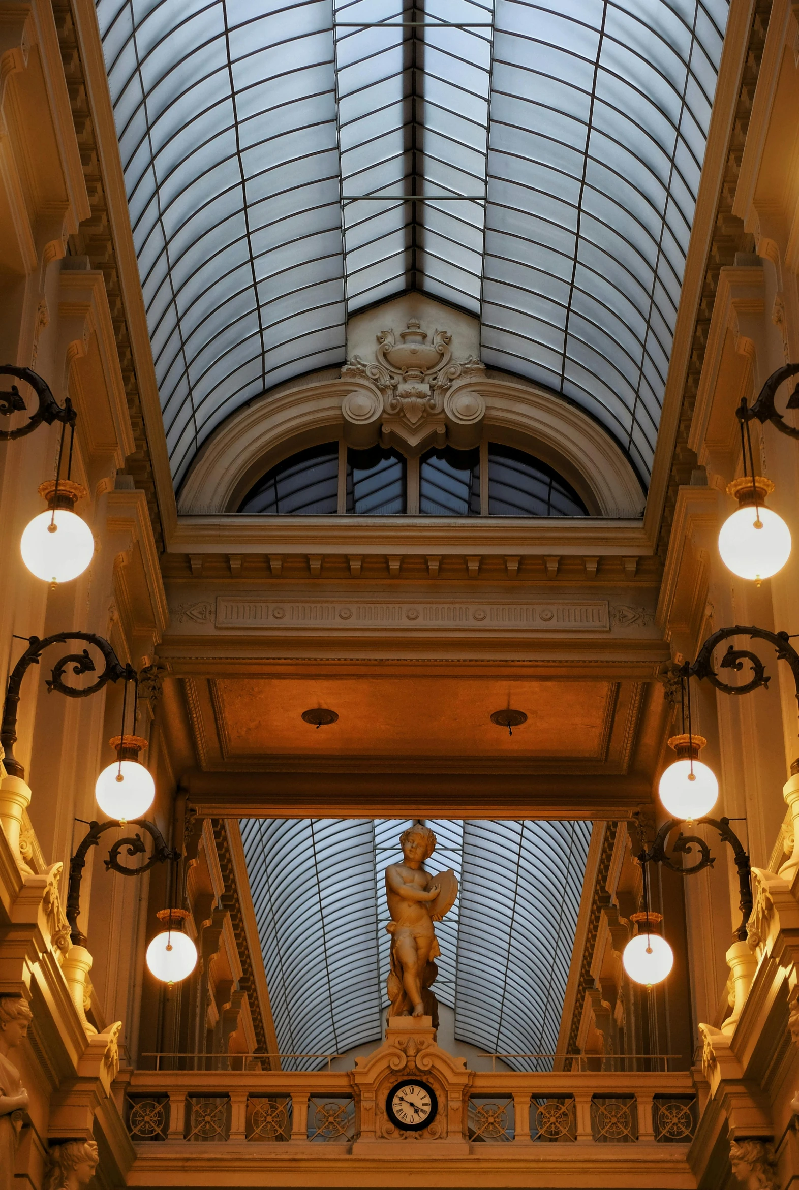 a clock mounted to the ceiling of a building, inspired by Gustave Boulanger, exceptional lighting, mall, with archways, skylights