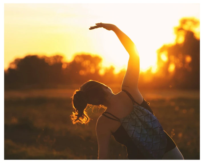 a woman stretching in a field at sunset, by Jessie Algie, pexels contest winner, yoga, warm sunshine, profile image, avatar image