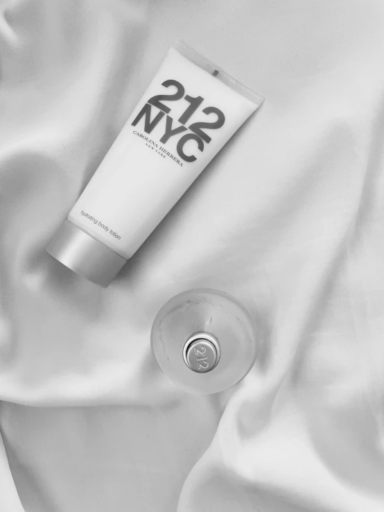 a bottle of body lotion sitting on top of a white shirt, a black and white photo, inspired by Alfred Jensen, modern minimalist f 2 0, mtg, 1.2, in style of chrome hearts
