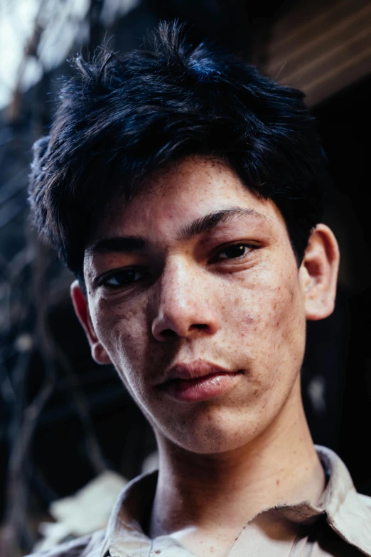 a close up of a person wearing a shirt, trending on unsplash, 14 yo berber boy, dirty olive skin, asian face, 35mm color photo