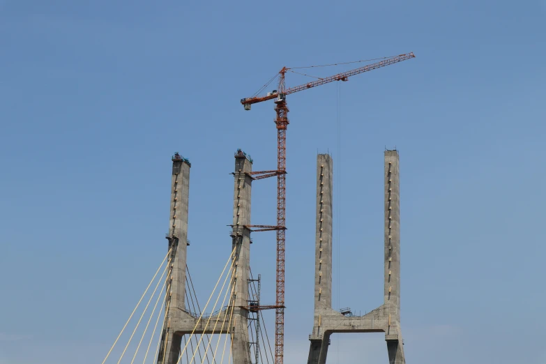 a crane that is sitting on top of a bridge, by Yasushi Sugiyama, pexels contest winner, constructivism, two giant towers, calcutta, pylons, 2 0 2 2 photo