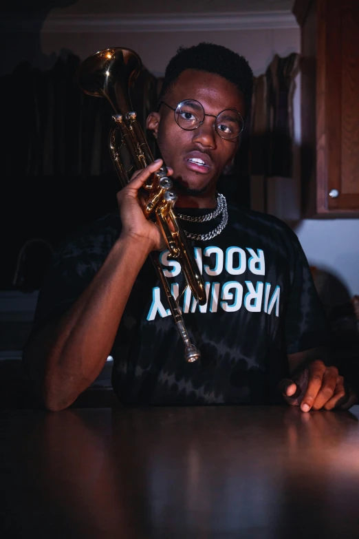 a man sitting at a table holding a trumpet, an album cover, by Theodore Major, trending on pexels, realism, bladee from drain gang, looking confused, low quality photo, wearing gold glasses