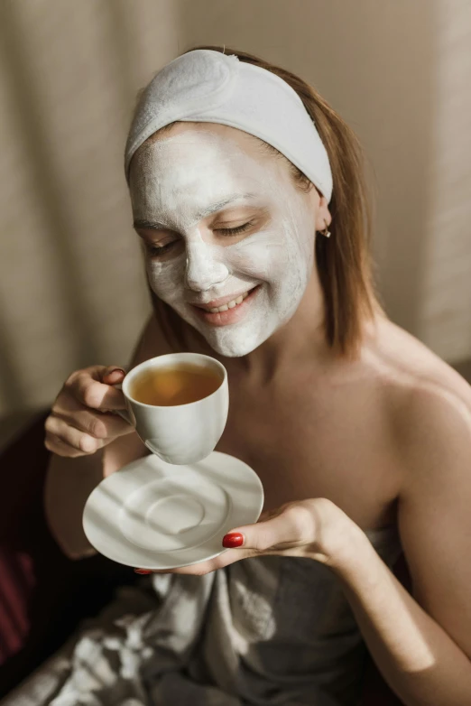 a woman with facial mask holding a cup of tea, by Julia Pishtar, trending on pexels, renaissance, white powder makeup, happy look, square, angelina stroganova