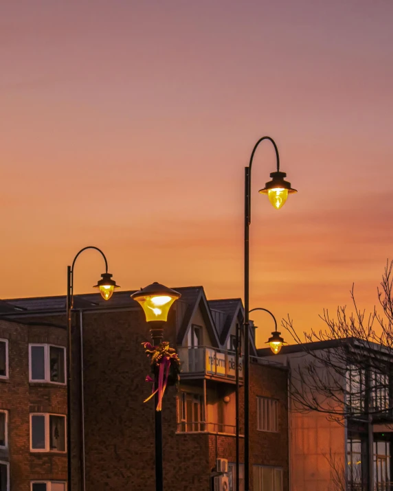 a couple of street lights sitting on the side of a road, by Jan Tengnagel, unsplash contest winner, realism, warm sundown, today\'s featured photograph 4k, city streetscape, well lit sky