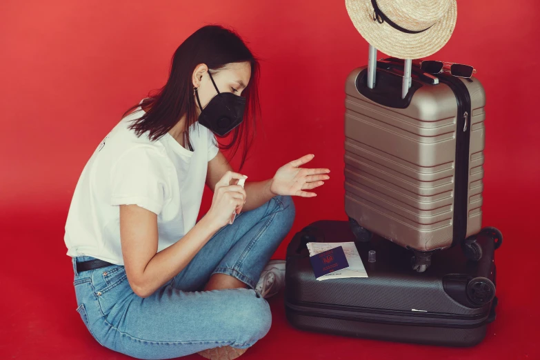 a woman sitting on the ground next to a pile of luggage, by Julia Pishtar, pexels contest winner, surgical mask covering mouth, red laser scanner, sitting on top of a cryopod, avatar image