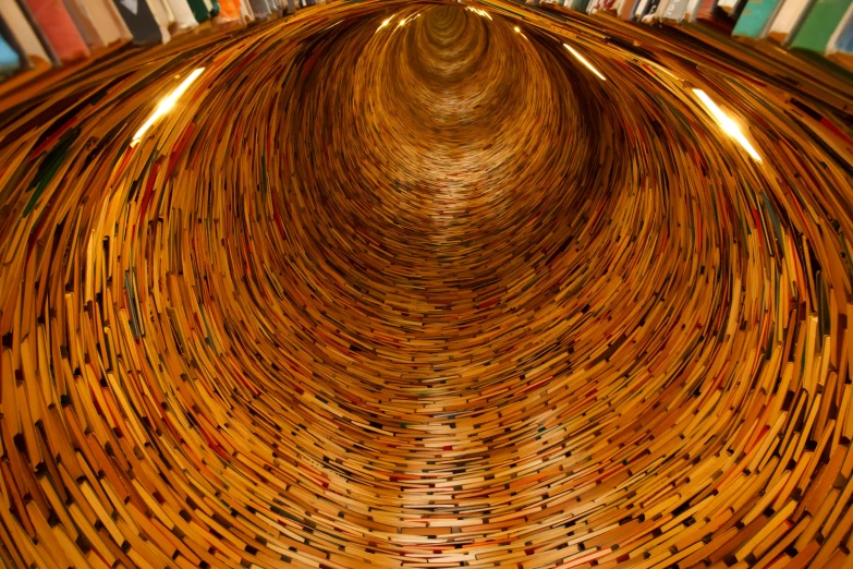 a book shelf filled with lots of books, by Konrad Witz, flickr, conceptual art, pulled into the spiral vortex, barrels, wideangle pov closeup, underground tunnel