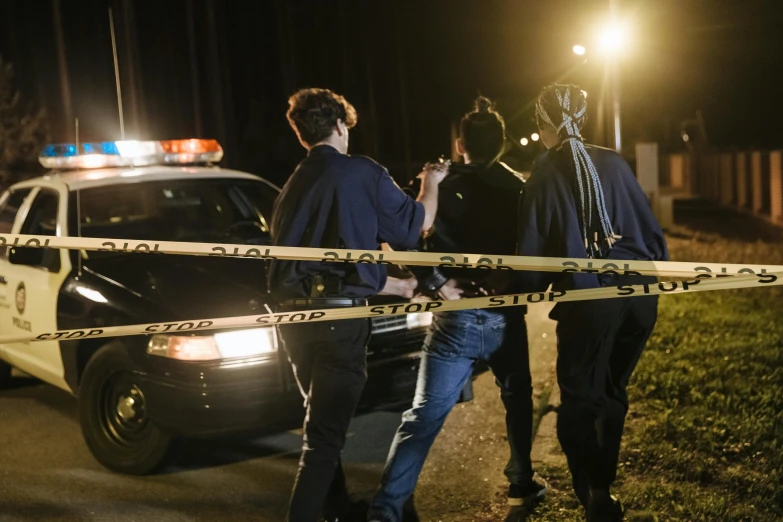 a couple of men standing next to a police car, happening, dark scene, bay area, thumbnail, getty images