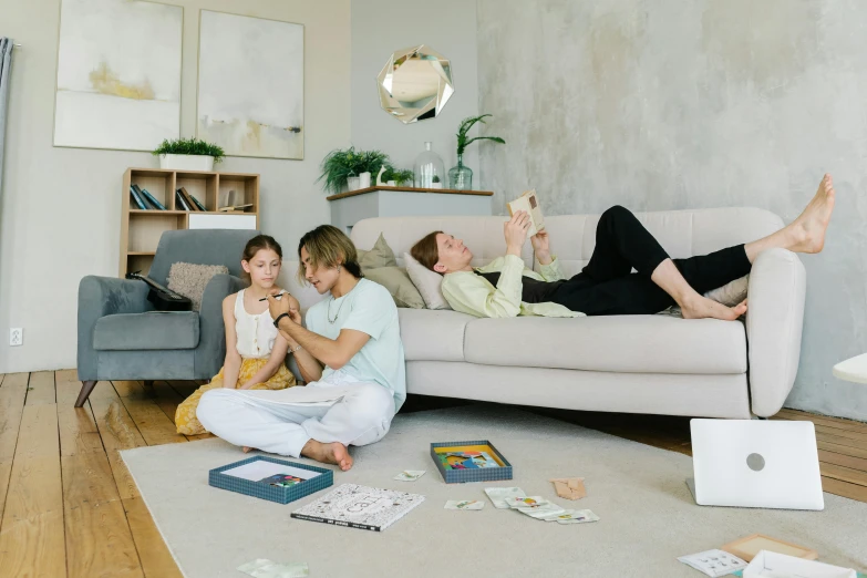 a group of people sitting on a couch in a living room, husband wife and son, with everything in its place, an aesthetically pleasing, laying down