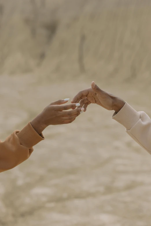 a man and a woman holding hands in the desert, trending on unsplash, still from a music video, sand color, lesbian, ignant