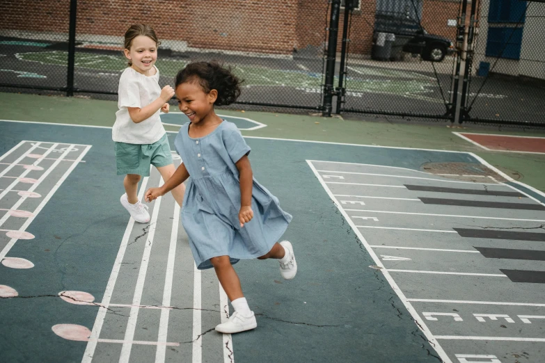 a couple of little girls standing on top of a tennis court, pexels contest winner, american barbizon school, running freely, denim, blue checkerboard dress, mixed race