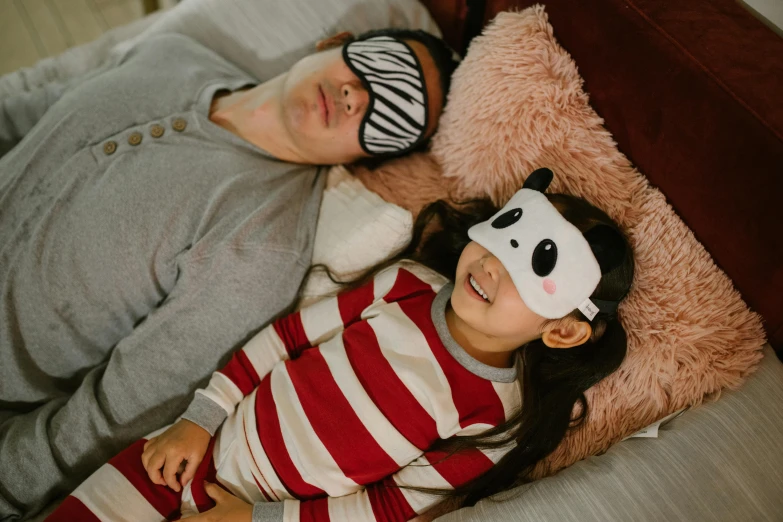 a man and a little girl laying on a bed, pexels contest winner, shin hanga, mask, manuka, striped, cosy