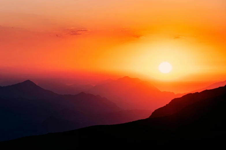 a person standing on top of a mountain at sunset, pexels contest winner, romanticism, bright yellow and red sun, subtle detailing, sunset panorama, intense colours