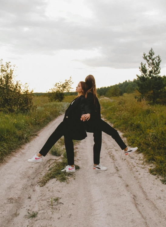 a couple of people standing on top of a dirt road, doing a sassy pose, 2019 trending photo, sofya emelenko, doing splits and stretching