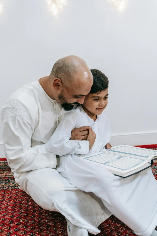 a father reading a book to his son on the floor, hurufiyya, wearing white robes, smooth feature