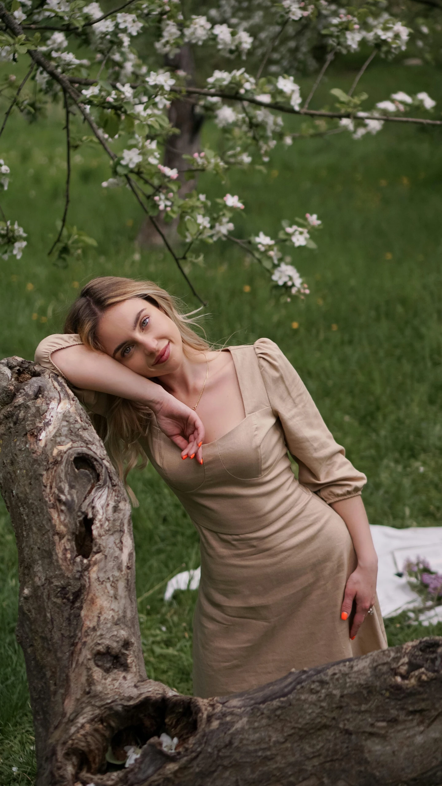 a woman leaning against a tree in a field, inspired by Elsa Bleda, pexels contest winner, renaissance, blonde beautiful young woman, high angle shot, anna nikonova aka newmilky, in a garden