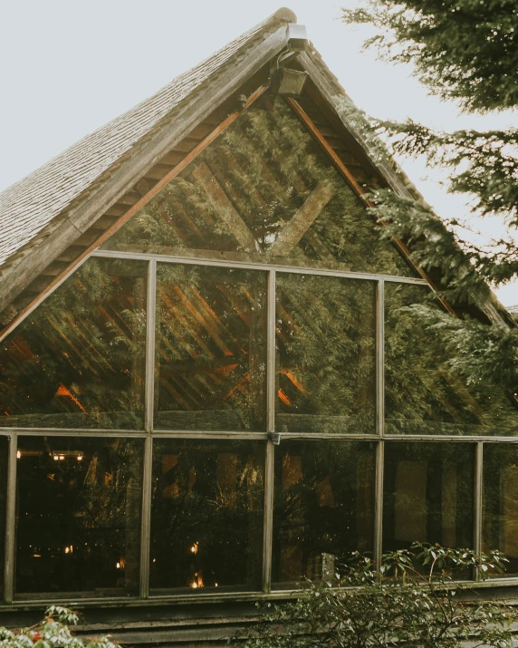 a couple of people that are standing in front of a building, lush greenery, inside a barn, glass room, trending photo