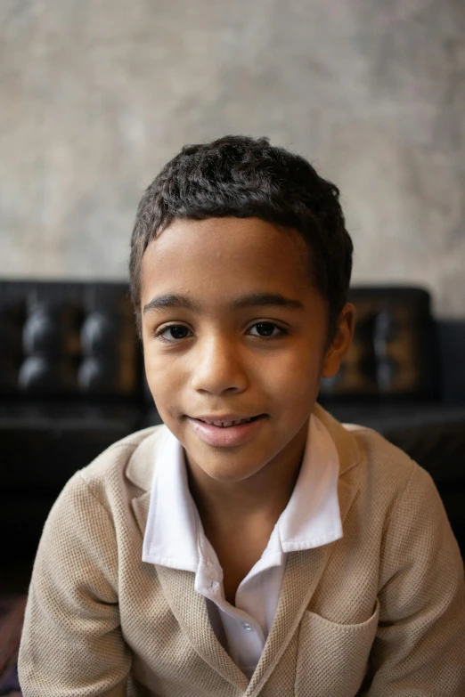 a little boy that is sitting down with a remote, ashcan school, headshot, dark-skinned, raden saleh, he is wearing a brown sweater