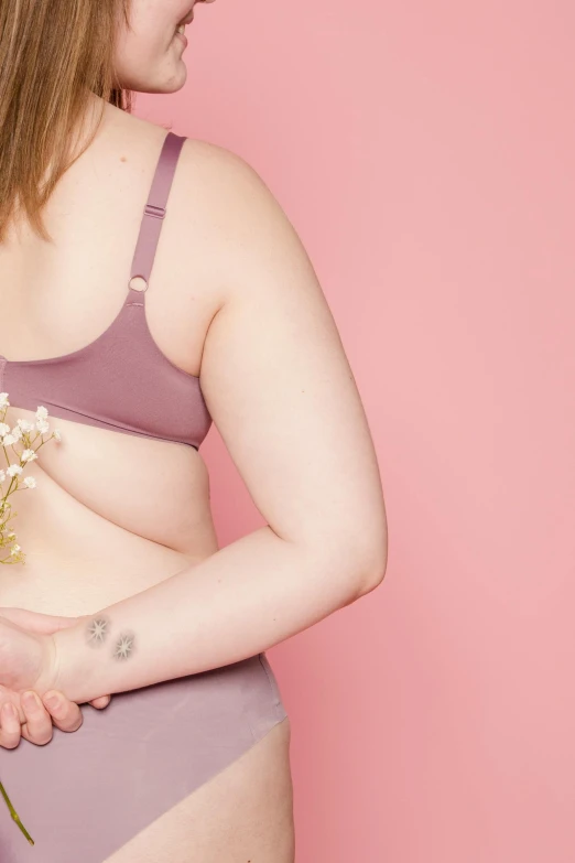 a woman in a bikini holding a bouquet of flowers, inspired by Ren Hang, trending on pexels, renaissance, morbidly obese, pale pink bikini, battle scars across body, gold bra