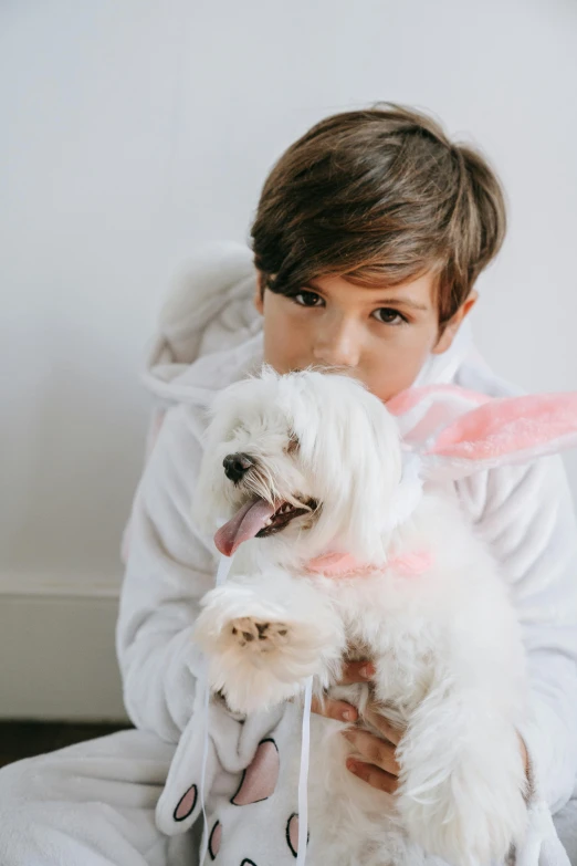 a little boy sitting on the floor holding a white dog, pexels contest winner, the bunny has pink fur, easter, profile image, soft but grumpy