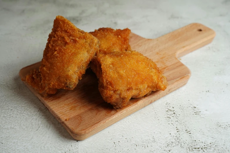 a wooden cutting board topped with fried food, thick fluffy tail, thumbnail, no wings, unedited