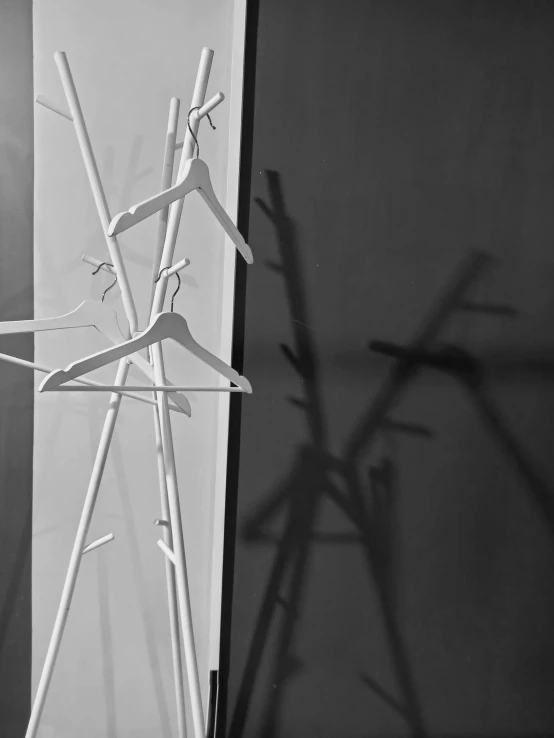 a black and white photo of clothes hanging on a rack, inspired by Peter Basch, conceptual art, paper cut out, vesa-matti loiri, sergey vasnev, shadows
