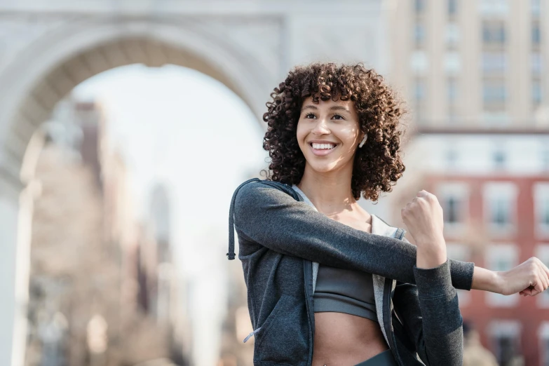 a woman posing for a picture in a city, happening, detailed sports bra, with a curly perm, sydney park, background image