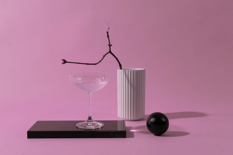 a glass sitting on top of a table next to a vase, a still life, inspired by Robert Mapplethorpe, postminimalism, cocktail bar, pink and black, still life of white xenomorph, detailed product image