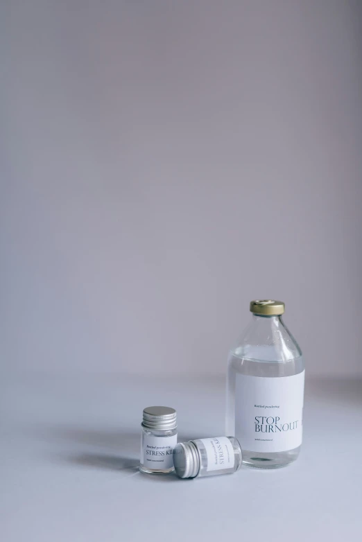 a bottle of water sitting on top of a table, unsplash, renaissance, clean white lab background, pills, pale grey skin, made in tones of white and grey