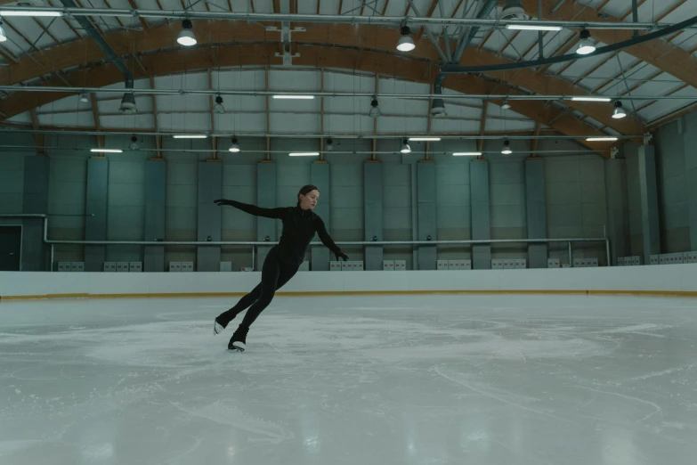 a man riding a skateboard on top of an ice rink, by Emma Andijewska, arabesque, **cinematic, diego fernandez, still frame, indoor picture