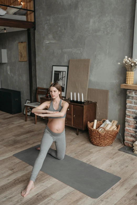 a pregnant woman doing yoga in a living room, by Adam Marczyński, pexels contest winner, happening, promo image, rustic, low quality video, sporty physique