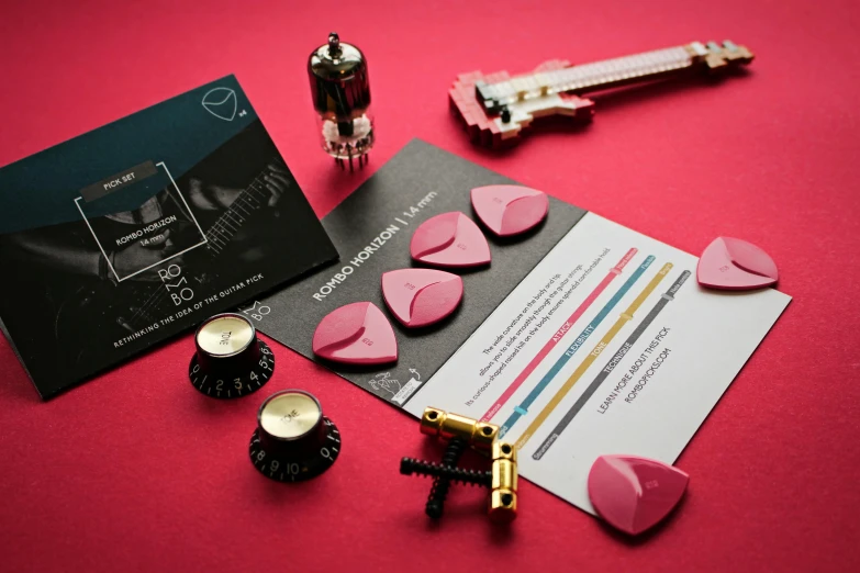 a close up of a bunch of items on a table, pink and black, acoustic information, detailed implants, indigo and venetian red