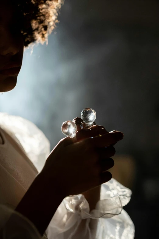 a close up of a person holding a glass, backscatter orbs, softly - lit, puff sleeves, partially cupping her hands