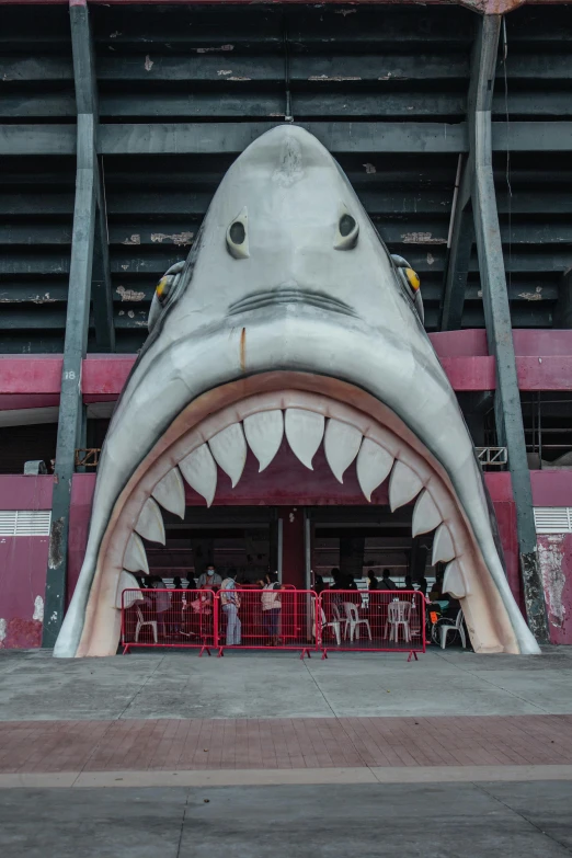 a close up of a shark's mouth on the side of a building, inspired by Simon Stålenhag, pexels contest winner, graffiti, stadium, maroon and white, huge gate, titanic ship exterior