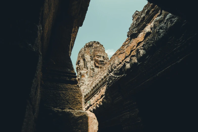 a large stone face in the middle of a cave, a statue, unsplash contest winner, angkor, looking to the sky, 2 0 0 0's photo, castles and temple details