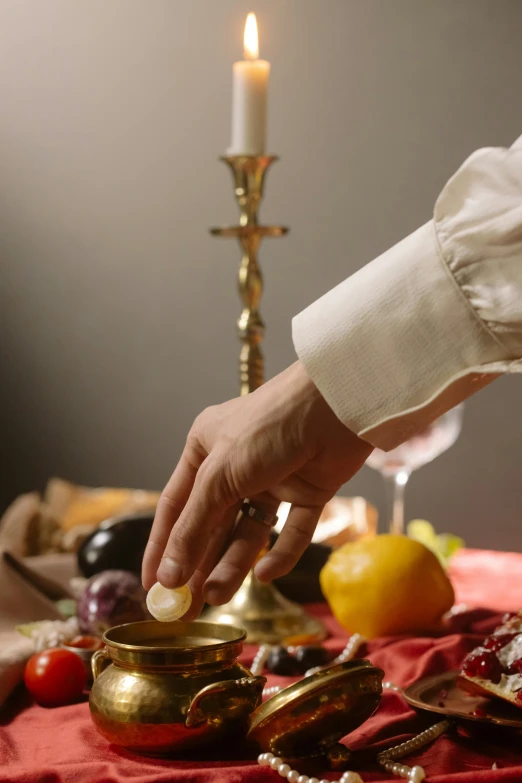 a person placing a coin into a bowl on a table, a still life, inspired by Matthias Stom, trending on unsplash, renaissance, ritual occult gathering, still frame from a movie, fine dining, fruit